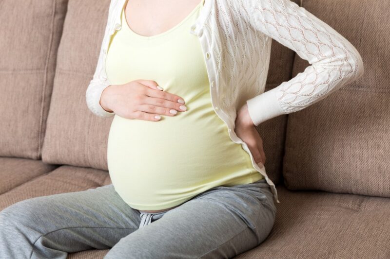 Pregnant woman holding belly showing abdominal changes during pregnancy