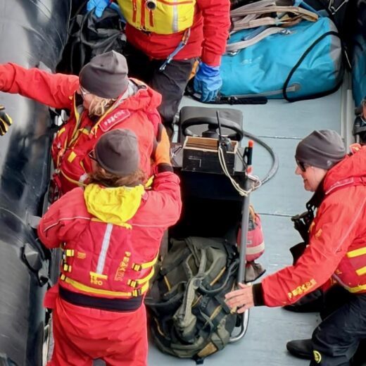 Antarctic kayaking preparation with team loading equipment onto boat