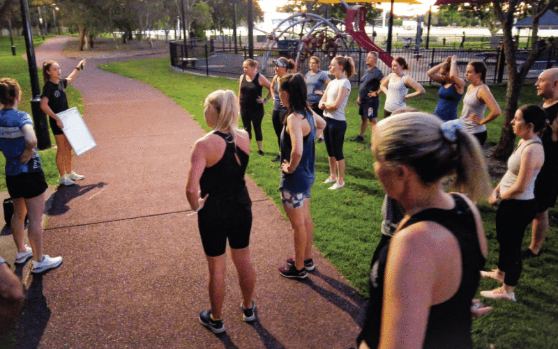 Group of people exercising outdoors in a park during a fitness session
