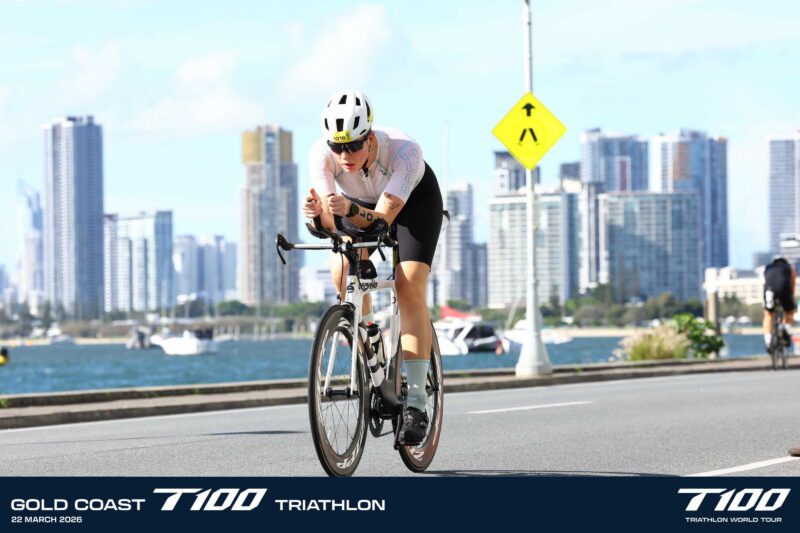 Sophie Dyer cycling during T100 triathlon race showing focus and endurance
