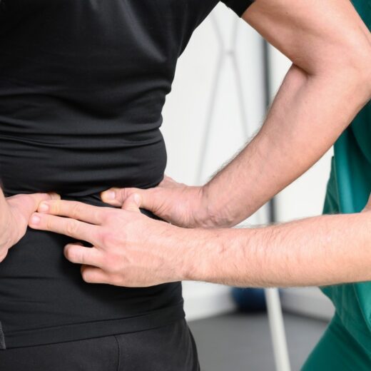 Physiotherapist providing lower back pain treatment in Brisbane during a clinical assessment