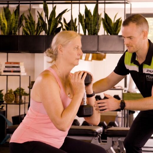 Osteoporosis strength training with a physiotherapist guiding an older woman